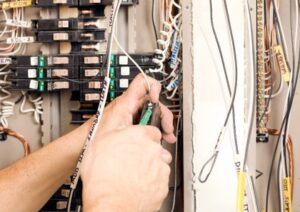 Close-up of an electrician working on an industrial electrical panel, showcasing the hands-on skills required for those learning how to become an industrial electrician.