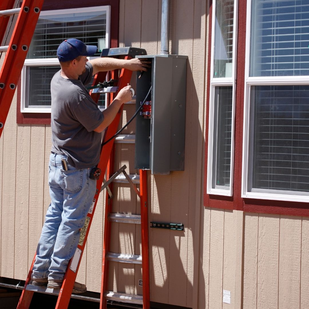 A professional Electrician Millers Point installing a new electrical panel on the exterior of a home to ensure safe and efficient power distribution.