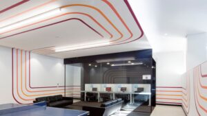 Modern office fitouts in Sydney featuring custom wall graphics, glass partitions, and collaborative workstations.
