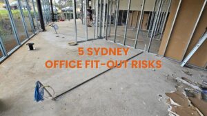 A Sydney office space under construction showing metal wall studs and blue electrical cabling on a concrete floor, managed by an office fit-out electrician.