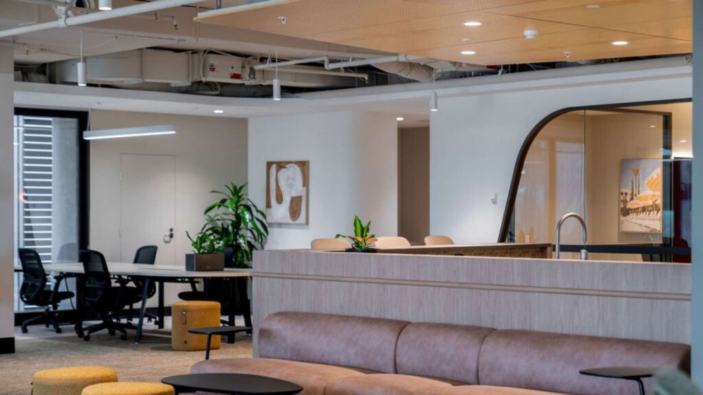 A bright office lounge and workspace featuring integrated lighting and hidden power infrastructure installed by professional electrical contractors.
