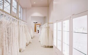 Recessed ceiling lights and backlit shelving integrated into retail lighting design for a bridal shop.