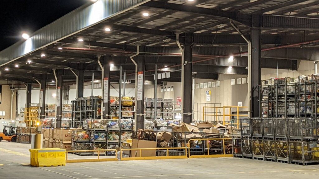 Industrial electrician installation of high-bay LED lighting and electrical infrastructure by Lightspeed Electrical at an Australia Post warehouse.