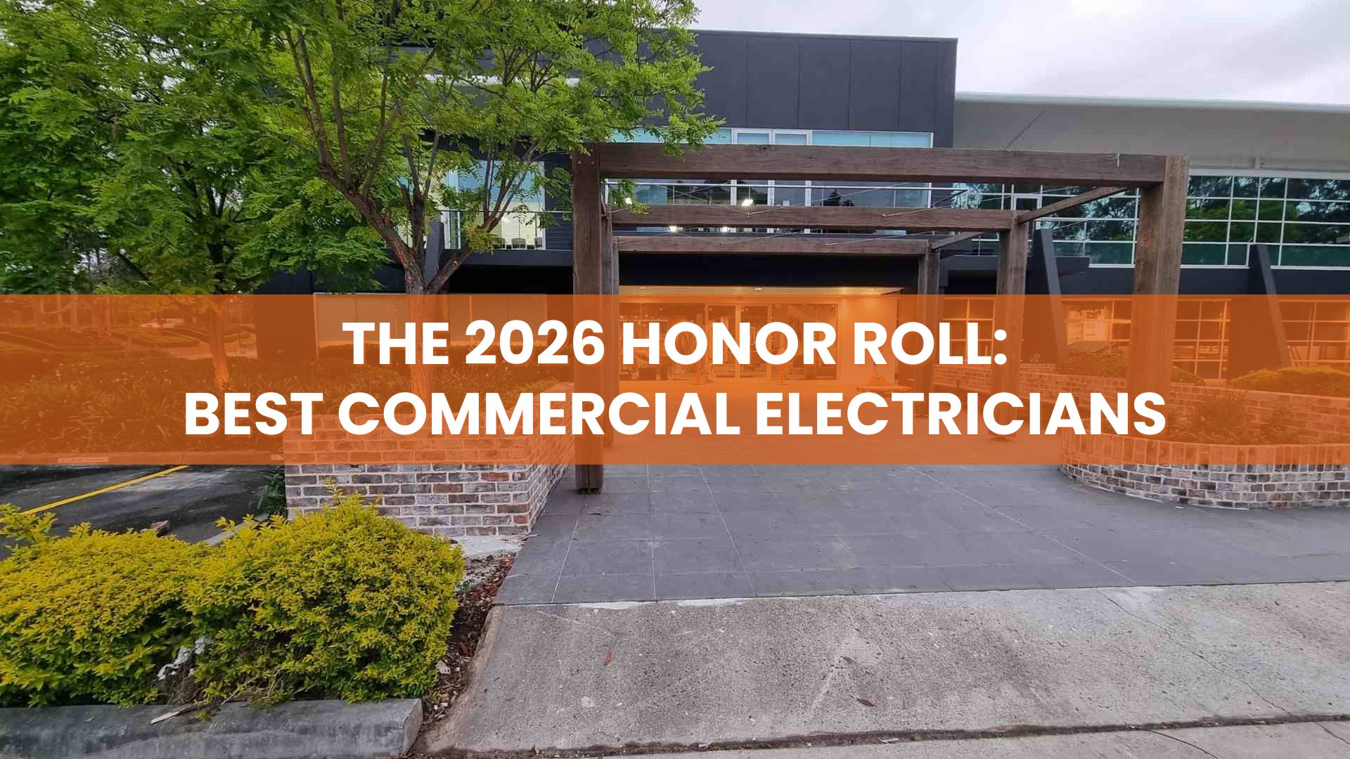 The 2026 Honor Roll: Best Commercial Electricians text over a modern commercial building entryway with a wooden pergola and brick landscaping.