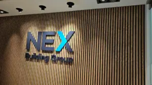 Nex Building Group illuminated office signage on timber slat wall.