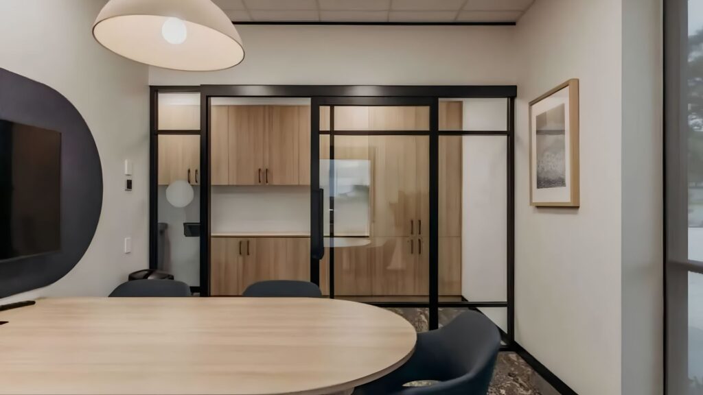 A sleek, minimalist corporate office lounge area featuring geometric cube pendant lighting, representing high-end electrical office fitouts.