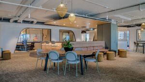 Modern office lounge featuring architectural pendant lights and track lighting, contrasting commercial space fit-outs in a commercial vs industrial electrician service comparison, by Lightspeed Electrical.