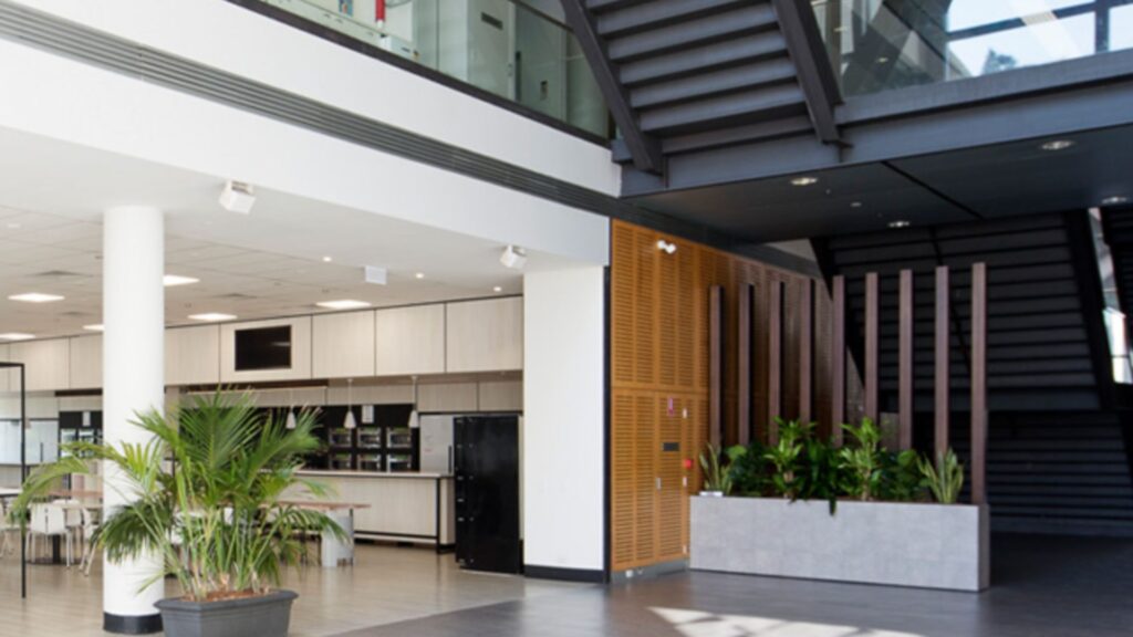 Large multi-level commercial building atrium featuring integrated commercial power systems and architectural lighting, highlighting key factors when choosing a commercial vs residential electrician, by Lightspeed Electrical.