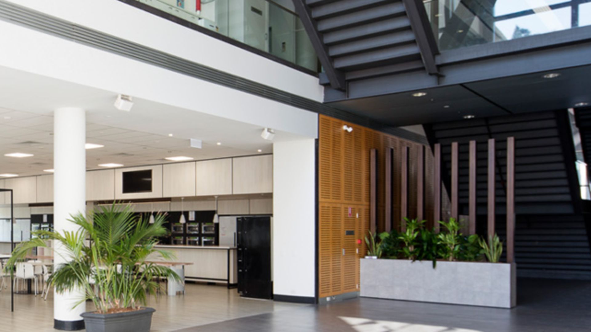 Large multi-level commercial building atrium featuring integrated commercial power systems and architectural lighting, highlighting key factors when choosing a commercial vs residential electrician, by Lightspeed Electrical.
